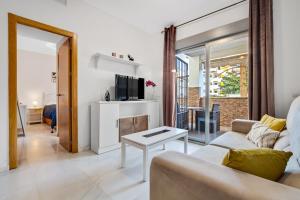 a living room with a couch and a tv at Golondrina by IVI Real Estate in Torremolinos