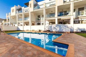 a swimming pool in front of a building at Golondrina by IVI Real Estate in Torremolinos