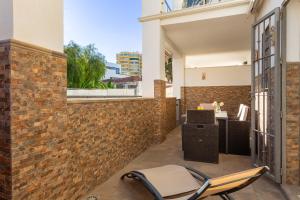 un patio con una silla y un escritorio en una pared de ladrillo en Golondrina by IVI Real Estate, en Torremolinos