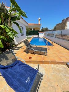 una piscina con una lona azul junto a una casa en Villa Juani, en Vinarós