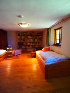 a living room with two beds and bookshelves at Eulenhof Vorpommern in Rossin