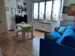 ein Wohnzimmer mit einem blauen Sofa und einem Tisch in der Unterkunft Appartamento Yuki in Dervio