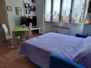 1 dormitorio con cama, mesa y ventanas en Appartamento Yuki, en Dervio