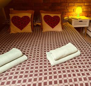 a bed with two pillows with hearts on it at Panorama Świętokrzyska in Górno