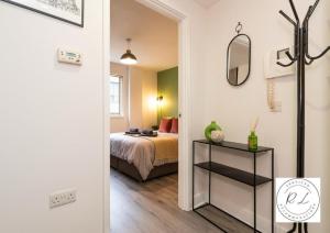 1 dormitorio con cama y espejo en Modern Spacious Apartment in Leicester City Centre with Free Parking!, en Leicester