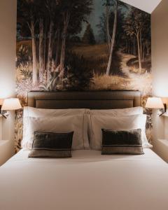 a bedroom with a painting above a bed with pillows at AlmaLusa Alfama in Lisbon