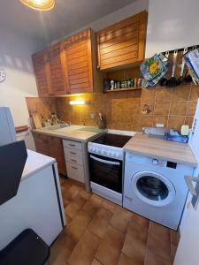 uma cozinha com uma máquina de lavar roupa e um lavatório em 4SOM23 Appartement proche centre-ville em Collioure