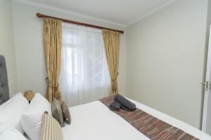 a bedroom with a bed and a window at Hallack Du Parc Modern Living in Port Elizabeth
