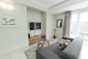 a living room with a couch and a tv at The Healing hideaway near St Georges Hospital in Port Elizabeth