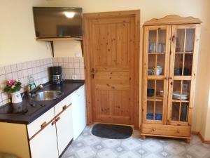 una cucina con lavandino e mobile in legno di Bärenhof Langenbernsdorf a Langenbernsdorf