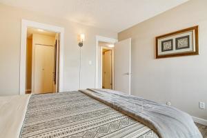 a bedroom with a bed with a blanket on it at Colorado Springs Condo with Fireplace Near Downtown in Colorado Springs
