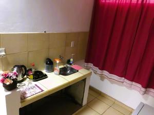 a bathroom with a sink and a red curtain at La Ofis Apart in Eldorado