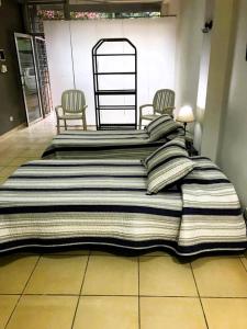 a large bed with two chairs in a room at La Ofis Apart in Eldorado