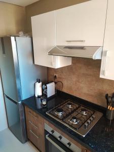 a kitchen with a stove and a refrigerator at Appartement Golf City Prestigia Marrakech in Marrakesh