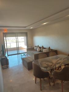 uma sala de estar com um sofá e uma mesa em Appartement Golf City Prestigia Marrakech em Marrakech