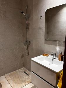 uma casa de banho com um lavatório e um chuveiro em Appartement Golf City Prestigia Marrakech em Marrakech