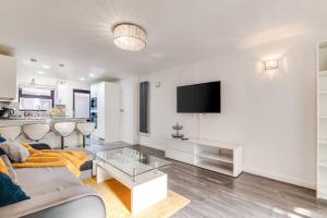 a living room with a couch and a tv at LiveStay - Stylish 3-Bed Gem in Trendy E1 London in London