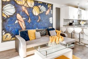 uma sala de estar com um sofá e um mural em LiveStay - Stylish 3-Bed Gem in Trendy E1 London em Londres