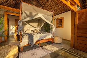 a bedroom with a bed with a mosquito net at Komba Cabana in Nosy Komba