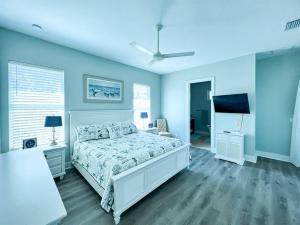 um quarto com uma cama branca e uma parede azul em Island Retreat: Your Exclusive Oasis Awaits em North Captiva