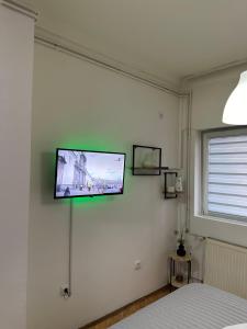 a flat screen tv on the wall of a bedroom at Loli apartman in Kraljevo
