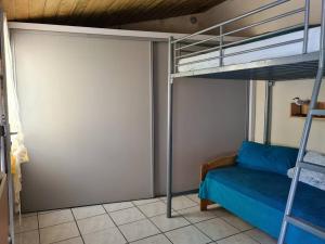 een slaapkamer met een stapelbed met een blauwe sprei bij Maisonnette des Sables Blancs avec jardinet Tréboul in Douarnenez