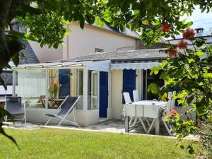 een huis met een tafel en stoelen op een patio bij Maisonnette des Sables Blancs avec jardinet Tréboul in Douarnenez