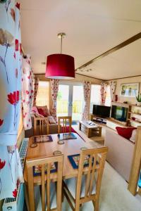 a living room with a table and chairs and a couch at Warren Haven in Dawlish Warren