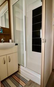 a bathroom with a glass shower and a sink at Warren Haven in Dawlish Warren