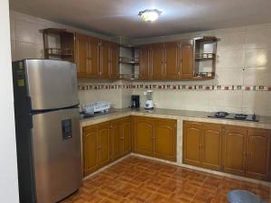 a kitchen with wooden cabinets and a stainless steel refrigerator at Elegante apartamento Ipiales in Ipiales