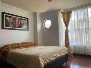 1 dormitorio con cama y ventana en Elegante apartamento Ipiales, en Ipiales
