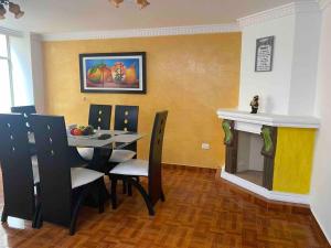 una sala da pranzo con tavolo, sedie e camino di Elegante apartamento Ipiales a Ipiales
