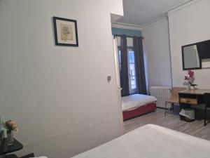 a room with a bedroom with a bed and a desk at Hotel de l'Academie in Nancy