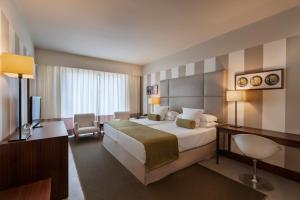 a hotel room with a large bed and a desk at Precise Resort El Rompido-The Hotel in El Rompido