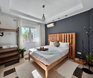 um quarto com uma cama grande e uma cabeceira em madeira em Sunny Blue em Sidi Daoud