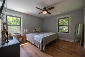 a bedroom with a bed and a ceiling fan at Mid-century Modern Impeccable Remodel with Hot Tub in Asheville