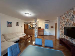 uma sala de estar com um sofá branco e cadeiras azuis em VUT EL PARQUE PISO 3DORMITORIOS Y 2 BAÑOS CON PISCINA EN VERANO. em Ciudad Real