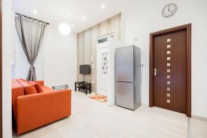- un salon avec un canapé orange et un réfrigérateur dans l'établissement Modern Westend CityCenter Home, à Budapest