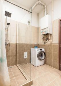 La salle de bains est pourvue d'une douche et d'un lave-linge. dans l'établissement Modern Westend CityCenter Home, à Budapest