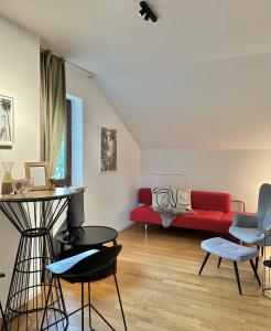 a living room with a red couch and chairs at Dachstudio Apartment in Ulm in Ulm
