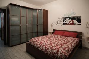 een slaapkamer met een bed met een rood dekbed bij La Casa di Zoe in Locate di Triulzi
