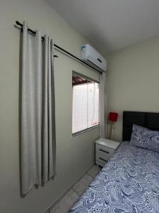 a bedroom with a bed and a window at Andres' Home Vila Bretas in Governador Valadares
