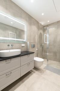 a bathroom with a sink and a toilet and a shower at Bossa Nova - modern 2 bedroom apartment in the center in Vilnius