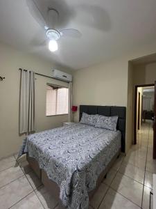 a bedroom with a bed and a ceiling fan at Andres' Home Vila Bretas in Governador Valadares