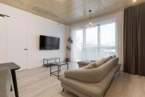 sala de estar con 2 sofás y TV de pantalla plana en Bossa Nova - modern 2 bedroom apartment in the center, en Vilna