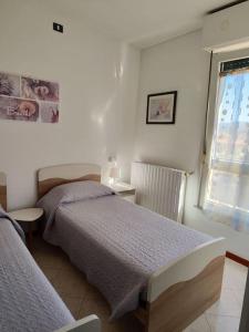 1 dormitorio con 2 camas y ventana en Casa vacanze Vespucci, en Grassobbio