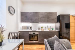 a kitchen with stainless steel appliances and a table at Livestay Stylish 1-Bed Apartment in Stratford in London
