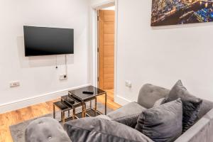 a living room with a couch and a flat screen tv at Livestay Stylish 1-Bed Apartment in Stratford in London