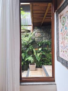a view of a garden through a window at Pousada Tekoá Indiana in Cachoeiras de Macacu