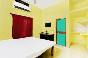 a bedroom with a white bed and a red door at Suman Niwas in Lucknow